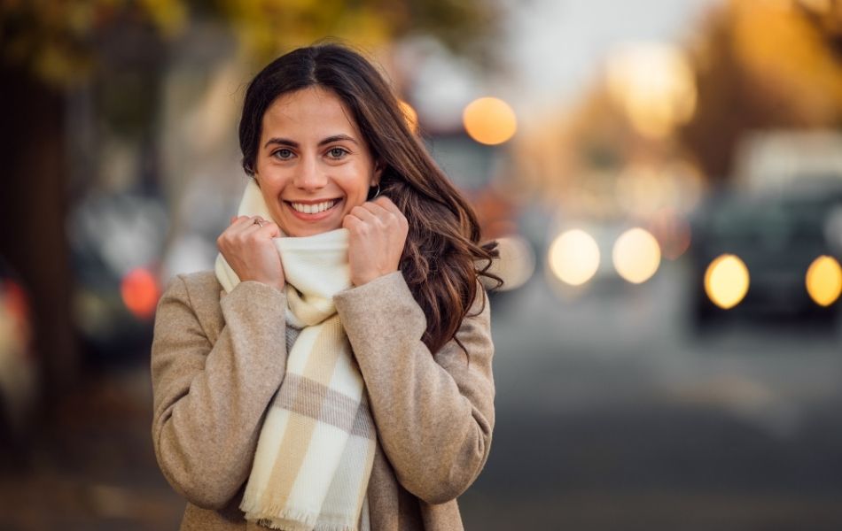 woman walking in cold weather with healthy skin showing